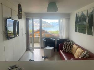a living room with a couch and a large window at Dearm Vacation home easy to arrive in Spiez