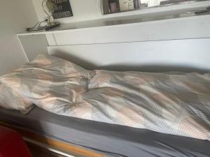 an unmade bed in a room with a shelf at Dearm Vacation home easy to arrive in Spiez +3 photos