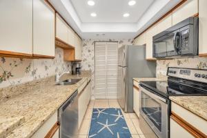 a kitchen with a sink and a refrigerator at Beach Club #429 in Saint Simons Island