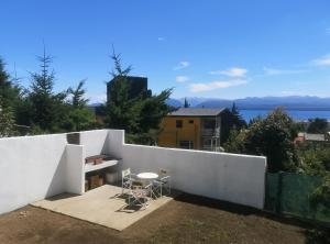 a white wall with a table and chairs on it at Refugio Patagonia Hostel in San Carlos de Bariloche