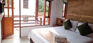 a bedroom with a bed and a large window at Vivelavilla suites VDL in Villa de Leyva