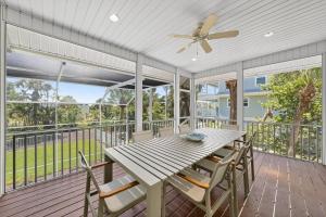 a screened porch with a wooden table and chairs at Sea Oats Oasis in Sanibel