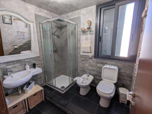 a bathroom with a shower and a toilet and a sink at La Perla Sicula Etna Pool in Agnone Bagni