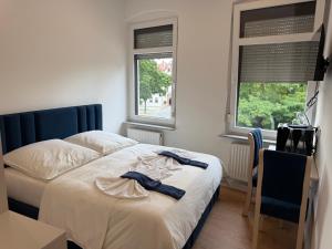 格劳豪Hotel &Restaurant Meteora的一间卧室,有一张床、一张书桌和两扇窗户