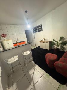 古鲁皮Essenza Compact的客厅里有一张红色沙发和两张吧凳