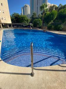 a swimming pool with a metal fence around it at Apartamentos Finestrat I-II in Cala de Finestrat