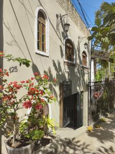 a building with a gate and flowers in front of it at Hospedaria Flor de Caju in Pipa