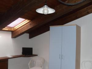 Cette chambre comprend une armoire blanche et une fenêtre. dans l'établissement Agriturismo Le Giare, à Gênes