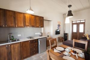 una cocina con armarios de madera y una mesa en una habitación en Ktima 1937 Kannides, en Droushia