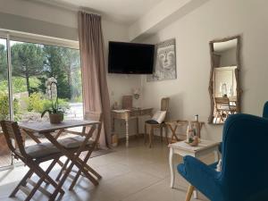 a living room with a table and a tv on the wall at La maison de la Cigale in Forcalqueiret