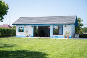 a small white house with a yard at Casa Lebăda in Jurilovca