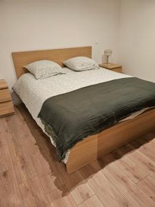 a bedroom with a large bed with a wooden headboard at Grande Sologne in Clémont