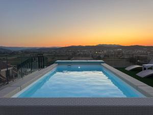 a swimming pool on top of a building with a sunset at Almarea Cirò Marina in Cirò Marina