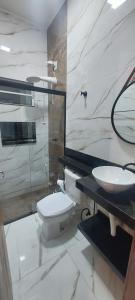 a bathroom with a toilet and a sink at Ótimo Apartamento 2 quartos mobiliado in Silvânia +6 photos