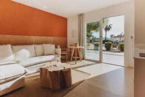 una sala de estar con un sofá y una mesa en Lago Resort Menorca - Villas & Bungalows del Lago, en Cala'n Bosch