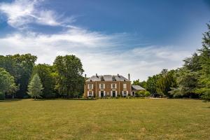 a large house with a large grass field at Manoir le Mingreaud Bungalows in Sainte-Gemme-la-Plaine