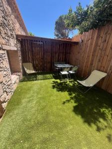 a backyard with a table and chairs and a fence at Chez Armand in Le Plan-de-la-Tour