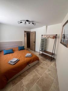 a bedroom with a bed with orange sheets and blue pillows at Chez Armand in Le Plan-de-la-Tour