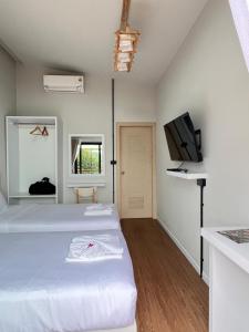a bedroom with two beds and a flat screen tv at Two Tree Cafe At Suanmuangthong in Ban Chi Noi