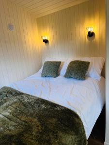 a bedroom with a white bed with two pillows at Hut in the hall in Bedale