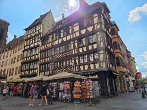 a large building with a market in front of it at Appartement d'exception spacieux, 2 chambres, terrasse privée, vue Cathédrale imprenable in Strasbourg