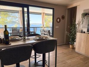 a kitchen with a table with chairs and a large window at Rosemary seaview luxury MH Mary in Drage
