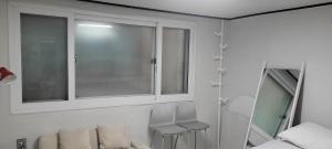baño con ventana y 2 taburetes en Black Stone House, en Seúl