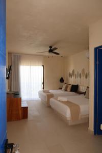ein Schlafzimmer mit zwei Betten und einem großen Fenster in der Unterkunft sunsteps casa Holbox in Holbox