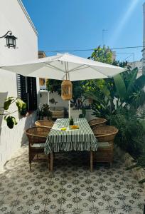 a table with a white umbrella on a patio at Casa Sasa in Porto Cesareo