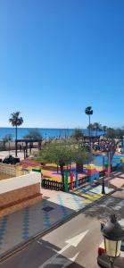 a park with a playground with the ocean in the background at Apartamento Sabimar Playa in San Luis de Sabinillas