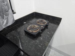 an electric stove on a counter in a room at Flat completo a 22 minutos do polo industrial in Aparecida de Goiania
