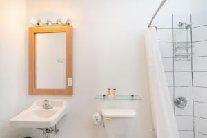 a white bathroom with a sink and a mirror at Casa Condado Hotel & Residences in San Juan +25 photos