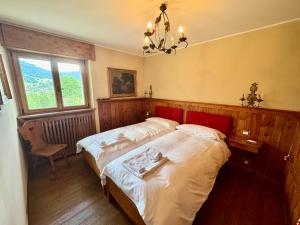 a bedroom with two beds and a chandelier at Villa Anna apartment - Center view - in Cortina dʼAmpezzo