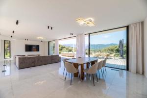 Un comedor y una sala de estar con mesa y sillas. en Villa Cala Serena, en Zonza