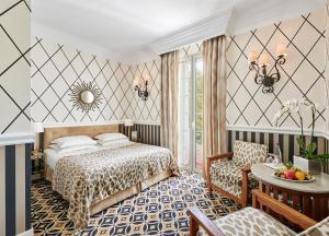 a hotel room with a bed and a table at Hôtel Belles Rives in Juan-les-Pins