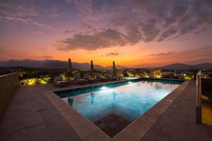 a pool with chairs and a sunset in the background at Oro Verde Portoviejo in Portoviejo