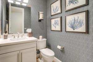 a bathroom with a toilet and a sink and a mirror at Patio and Outdoor Kitchen Manteca Family Home in Manteca +26 photos