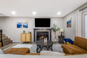 a living room with a fireplace and a flat screen tv at Adventures on Alleghany in McGaheysville