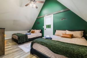 a bedroom with two beds and a green wall at Adventures on Alleghany in McGaheysville