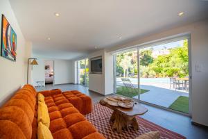 een woonkamer met een grote oranje bank en een tafel bij Villa Joia 2 vue mer 7 chambres in Saint-Tropez