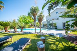 een villa met zwembad en palmbomen bij Villa Joia 2 vue mer 7 chambres in Saint-Tropez