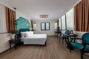 a bedroom with a white bed and chairs and windows at Azen Lakeside Hotel & Travel in Hanoi