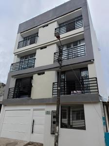 a white building with a lot of windows and a pole at Apartamento Completo Ibague - Parqueadero - Ocobo in Ibagué +3 photos