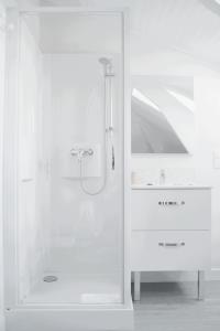 a white bathroom with a shower and a sink at Hotel Ker Lehn - La Plage in Piriac-sur-Mer +44 photos