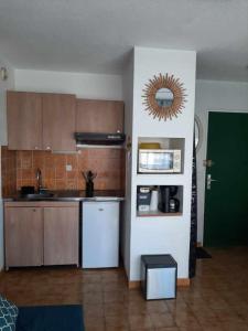a kitchen with brown cabinets and a green door at PORT et PLAGE in Le Barcarès +3 photos