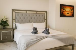 two stuffed animals sitting on top of a bed at Sunset Suites Mazatlán at Lomas de Mazatlán in Mazatlán