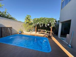 a swimming pool sitting on a deck next to a house at Casa Temporada Aconchego e tranquilidade 1 in Bonito