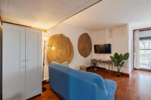 a living room with a blue chair and a television at Serenity Troia in Troia