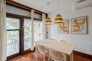 a dining room with a white table and chairs at Serenity Troia in Troia
