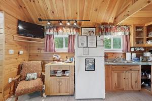 a kitchen with a refrigerator and a chair in a cabin at K1 Cottage in Greenville